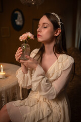 Woman Smelling Flowers in Warm Candlelit Setting