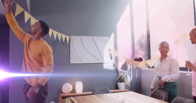 Mustard man reaching for bunting as team's hanging flags and adding balloons for office party