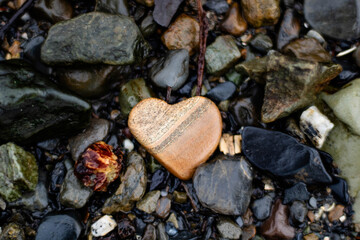 Natural heart-shaped lover's stone on a wild stone beach with a romantic mood
