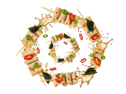 Flying odeng skewers with swirling hot broth splash, seaweed flakes, sliced peppers, and rising steam captured in crisp commercial studio lighting