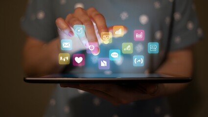 Person s hands interacting with a tablet display showing a grid of colorful digital application icons