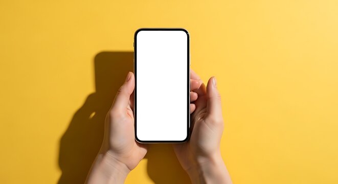 Hands holding smartphone with blank white screen on yellow background