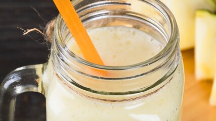 Refreshing homemade smoothie in a mason jar with orange straw