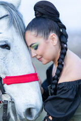Charming European lady posing with a majestic white horse in an open field, symbolizing freedom, calmness, and connection with nature.