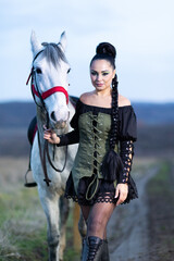 Charming European lady posing with a majestic white horse in an open field, symbolizing freedom, calmness, and connection with nature.