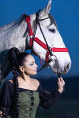 Charming European lady posing with a majestic white horse in an open field, symbolizing freedom, calmness, and connection with nature.