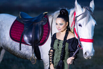 Charming European lady posing with a majestic white horse in an open field, symbolizing freedom, calmness, and connection with nature.