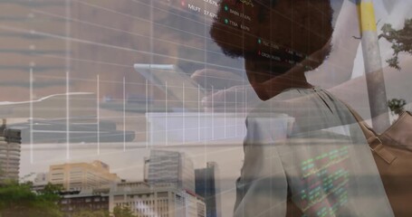 Woman shading eyes and scanning skyline, then raising tablet and studying overlaid finance charts - Powered by Adobe