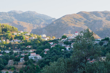 Mountain village Lakkoi in western Crete surrounded by pine forest on sunny day