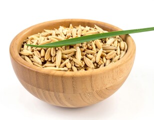 Close-up of unhusked rice in a wood bowl with a green leaf on a white background