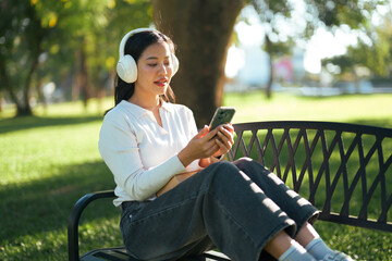 Woman relaxing on park bench listening to music