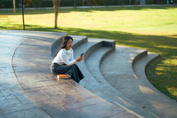 Young woman relaxing outdoors playing mobile phone