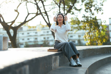 Young woman enjoying music relaxing outdoors in park