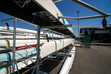 Rowing boats stored on outdoor racking systems at Watersports Centre at Strathclyde Country Park Scotland. UK. The boats are long, narrow, and lightweight vessels for the sport of competitive rowing. 