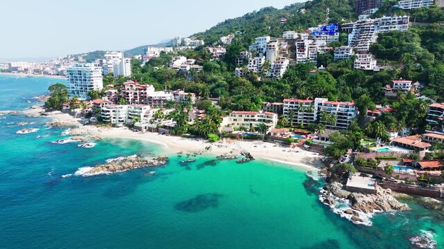 Conchas chinas beach with turquoise water and hillside resorts on a sunny day in mexico