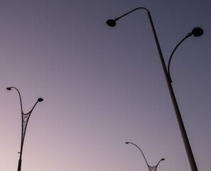 Minimal Silhouetted Streetlights Against Soft Evening Sky Gradient