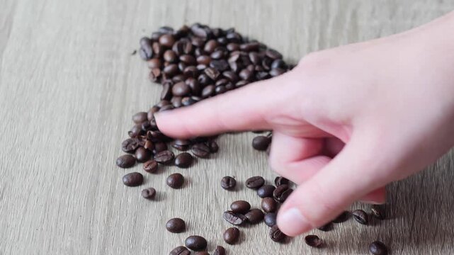 Coffee beans heart shape - Finger Making a Heart Shape from Roasted Coffee Beans