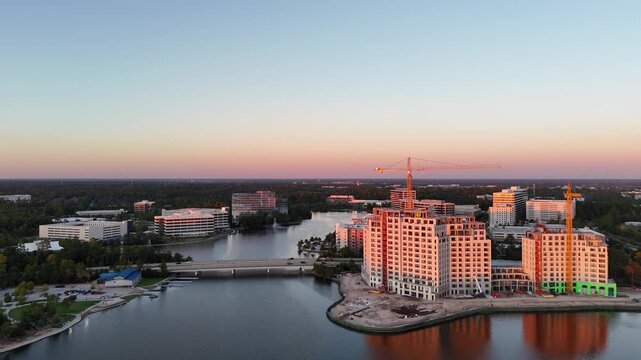 Aerial view of ongoing construction of tall building by the lake at sunset in USA