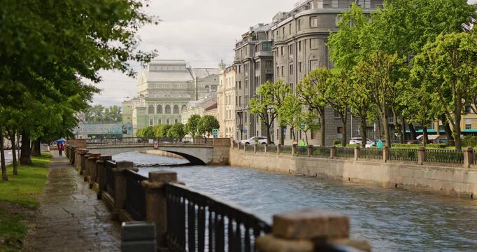 Russia, St.Petersburg, the embankment of the Kryukov Canal and the Griboyedov Canal, boats floating on the river, people strolling along the embankment, colorful facades of buildings