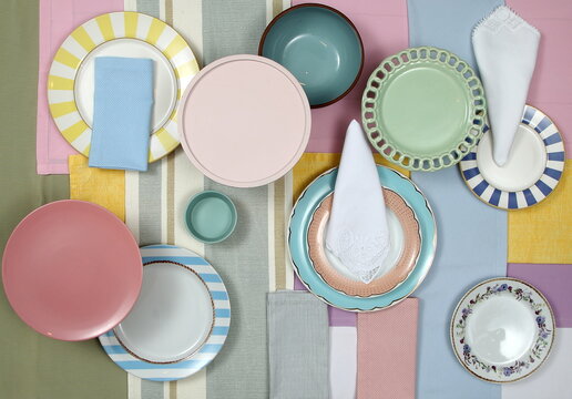 A sophisticated and colorful table setting with plates, glasses, and cutlery in themed colors, seen from above.