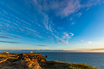 Stunningly beautiful sunset over the ocean as seen from the cape cliffs near the lighthouse of Vik, small city in Southern Iceland, travel tourist destination and sightseeing