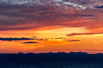 Stunningly beautiful sunset over the ocean as seen from the cape cliffs near the lighthouse of Vik, small city in Southern Iceland, travel tourist destination and sightseeing