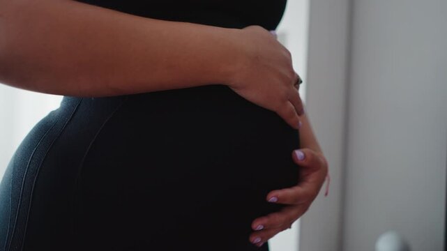Pregnant woman touching her belly in anticipation