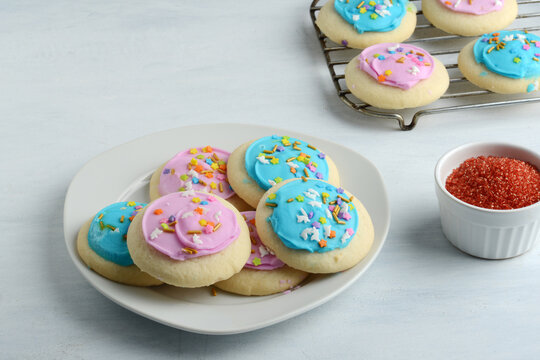plate of pink and blue sugar cookies with colorful sprinkles