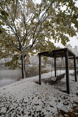 Snow-covered swing on the shore of Golubinsky pond. Moscow