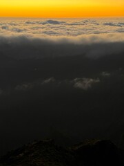 Pico do Arieiro is the third highest peak on Madeira Island and is one of the most popular sunrise spots.,a view from a drone of a landscape shrouded in clouds
