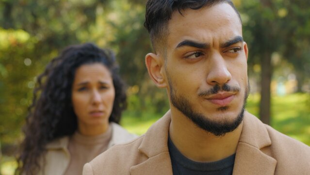 Emotional quarrel hispanic couple in autumn park ignoring separated man offended mad negative woman yelling talking on background family conflict break up outdoors girlfriend scolding boyfriend upset