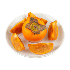 Whole and sliced ripe persimmons on a white plate with a white background