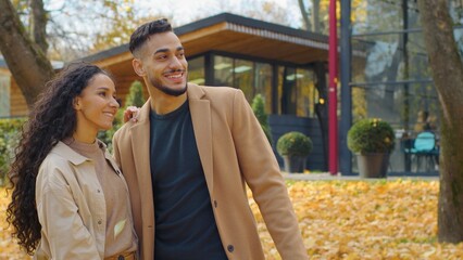 Hispanic happy couple in love outdoors talking in city fall season man and woman communicate in...