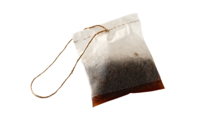 a tea bag with loose dark brown liquid inside, tied at the top and hanging from a string, isolated on a white background. detailed, high-quality photographic stock image with extremely sharp focus and