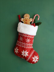 Christmas Stocking with Gingerbread Cookie and Candy Cane on Green Background – Festive Holiday Decoration