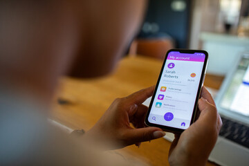 Adult focused on mobile banking app at home