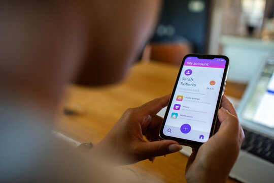 Adult focused on mobile banking app at home