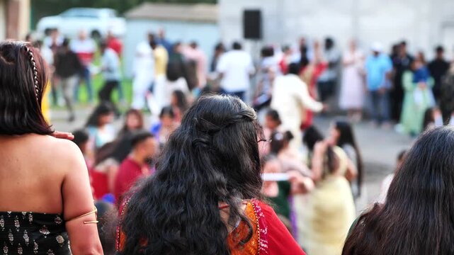 Indian women watching people celebrating Ganesh Chaturthi festival on street