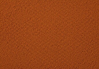 Fototapeta premium Extremely close up texture shot of fine, reddish-brown ground cinnamon spice covering the entire surface uniformly creating an abstract background, cinnamon, aromatic, reddish