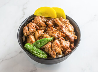 Delicious Teriyaki Chicken Donburi bowl ready to eat, garnished with pickled radish and peppers on pristine marble surface