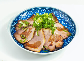 Delicious char siu pork slices with vibrant green onions on a blue patterned plate perfect for Asian cuisine promotions and restaurant menus