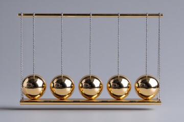 Six metallic pendulum balls demonstrate the principles of motion and energy transfer in a controlled environment with a neutral background