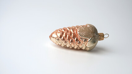 Vintage Christmas tree decoration - a glass pine cone with decorative glitter on top on a white background. Copy space.