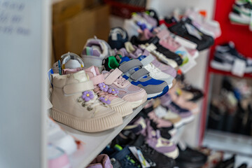 A vibrant assortment of children's shoes on display, showcasing various styles and colors in a retail setting.
