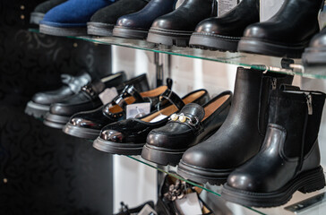 A close-up view of a shelf showcasing a variety of stylish shoes, including boots and flats, perfect for fashion enthusiasts.