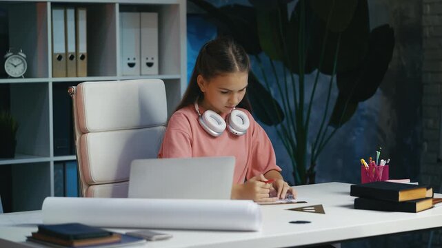 Teen girl creating building blueprint, learning architecture and design basics
