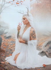 art photo real person fantasy young elf woman holding pink gerbera flower. close-up beauty face sexy eyes lips fairy tale girl, blonde ash hair white dress trendy make-up. myth faun pixie sexy lady 