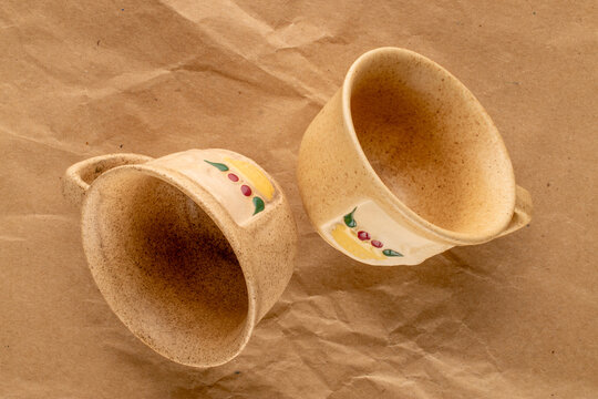 Two ceramic cups on kraft paper, close-up, top view.