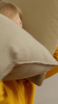 Portrait emotional funny naughty child little girl covering ears with pillows screaming bad behavior playing daughter baby scream yelling crazy messy shouting displeased refuse listening noise at home