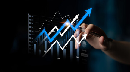 This image showcases a hand holding a pen while analyzing a digital financial chart with...